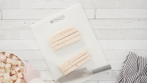 Flat lay. Step by step. Cutting homemade candy cane fudge on a white cutting board.