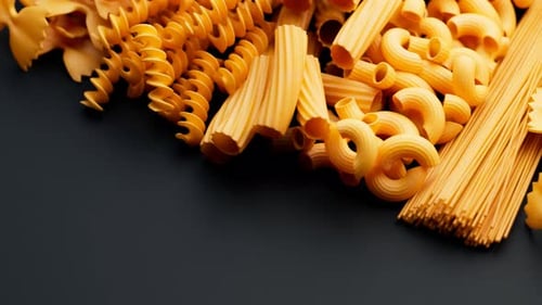 Assorted Raw Pasta Types Slowly Panning on Dark Background
