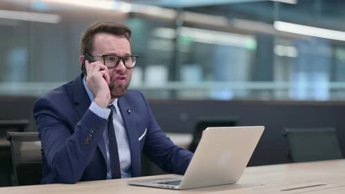 Man Arguing on Cell Phone in Corporate Office