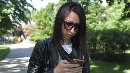 Woman Searching Information on a Smart Phone on the City Street. Technology and Lifestyle Concept.