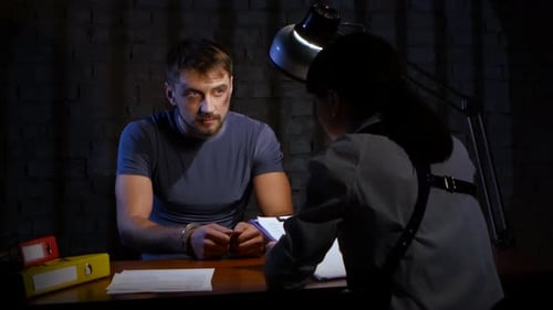 Man in Handcuffs Interrogated by Police Detective