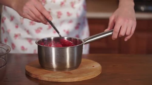 Close Up Shot of a Saucepan with Fruit Syrup That Stirs the Cook with a Spoon