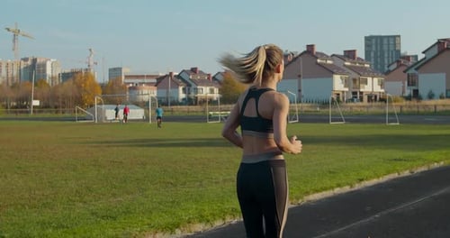 Strong Fitness Girl Running in Stadium. She Is Celebrating the End of Her Workout