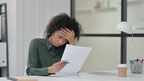 Woman Reviewing Documents with a Concerned Expression