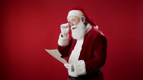 Santa Claus Reads Letter in Red Suit