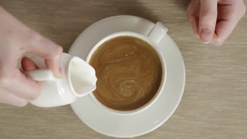 Adding Milk to Coffee in Mug Close Up