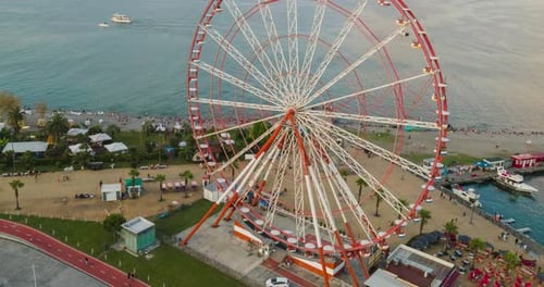 Aerial hyperlapse of Ferris wheel, alphabetic tower, skyscrapers and embankment of Batumi city