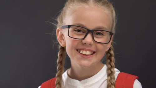 Smiling Girl with Braids Wearing Glasses