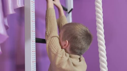 Energetic Boy Climbing Wall Ladder at Home