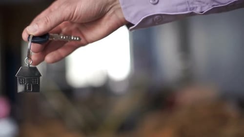 Hand Holding Key with House Keychain