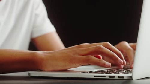 Hands Typing on a Silver Laptop Keyboard