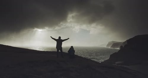 Two people stand on hilltop
