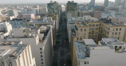 Drone Flying Above City Streets of Downtown Los Angeles, Cars Below Surrounded by Beautiful Building