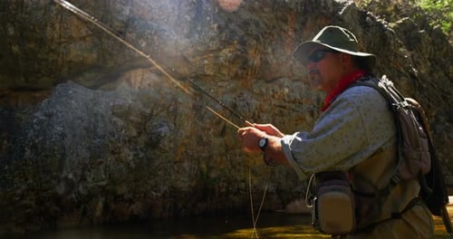 Fisherman fly fishing in river