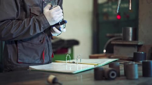Factory Worker Measuring Detail. Man measuring part with callipers in workshop
