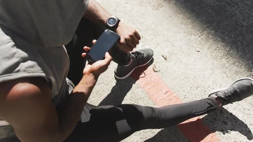 Adult Uses Phone During Urban Workout Break