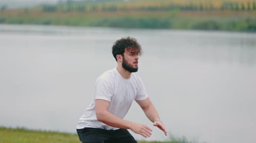 Young Adult Doing Squats by a Lake