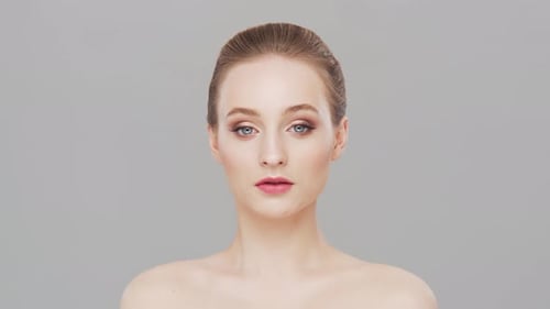 Studio portrait of young, beautiful and natural woman over grey background.