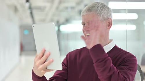 Smiling Man on Tablet Video Call in Office