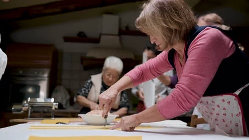 Aged women cooking tortellini together in kitchen