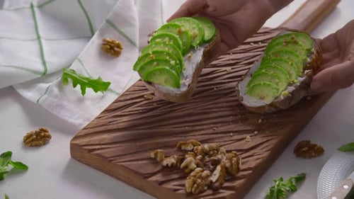 Placing Fresh Avocado Toast on a Wooden Board