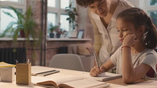 Adult Woman Helping Young Girl with Homework