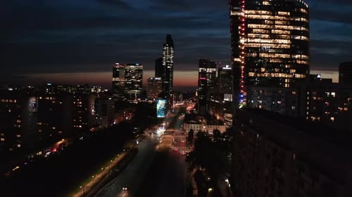 Night City Scene High Rise Illuminated Buildings Along Wide Street