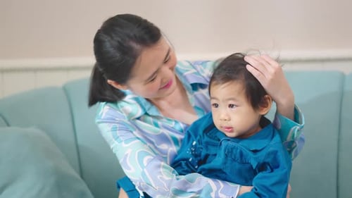 Schöne asiatische Familienmutter und kleiner Junge, Sohn, die zusammen küssen und umarmen