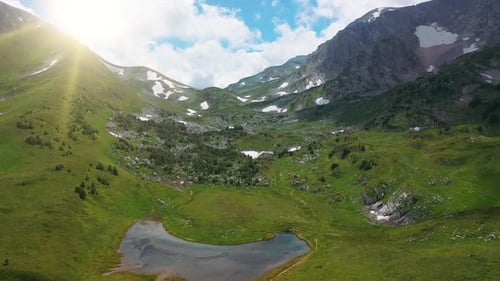 Flying Over Breathtaking Beautiful Mountain Covered with Dense Grass, Trees and Stones Under Steam