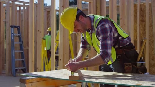 Construction worker preparing to cut board