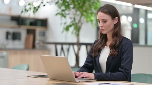 Woman Working on Laptop in Modern Office