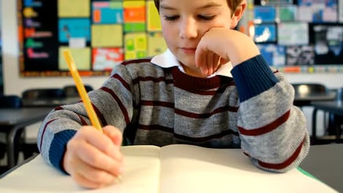 Boy doing homework in classroom 4k