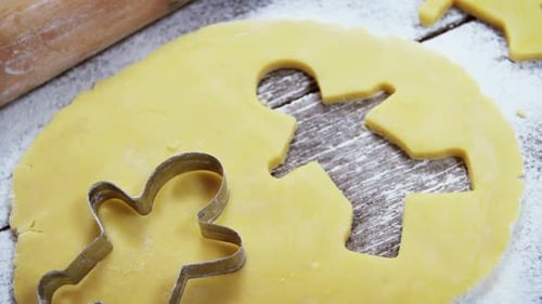 Gingerbread Man Cookies Being Cut From Dough