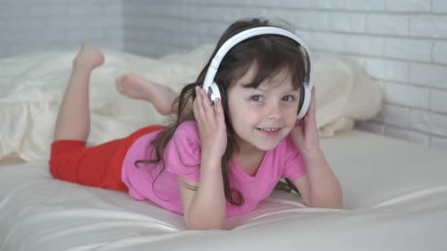 Little Girl Listening to Music on Bed