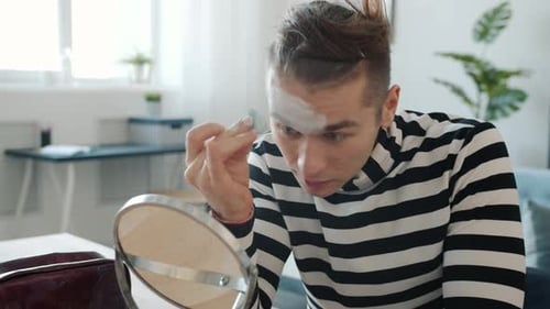 Young Adult Applying Makeup in the Mirror