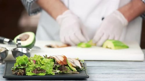 Chef préparant une salade à l'anguille.