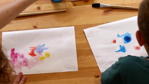 Boy preschooler and girl teacher draw in the art classes. Paint on paper with a brush. Preschool