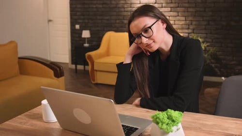 Focused Smiling Businesswoman in Glasses Using Laptop at Home Office