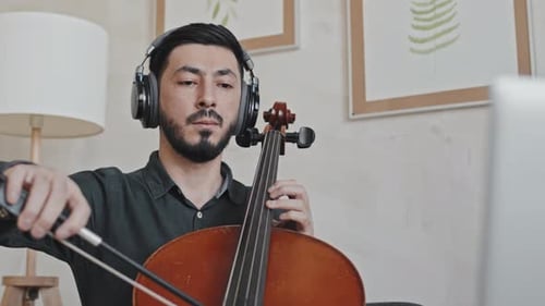 Man With Headphones Playing Cello Indoors