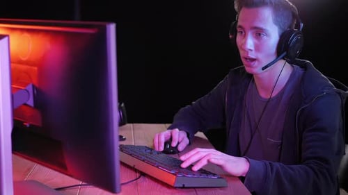 Young Adult Playing Video Game at Desk