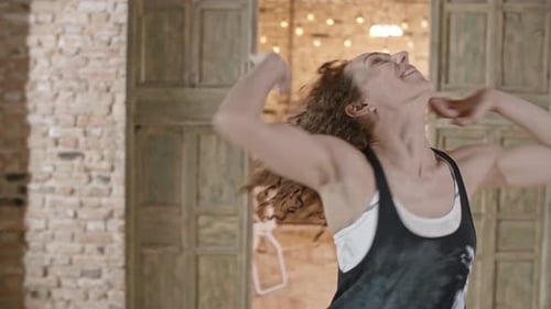 Woman Dancing in an Airy Brick Room