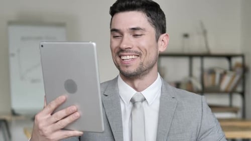 Man on Tablet Video Call in Workplace