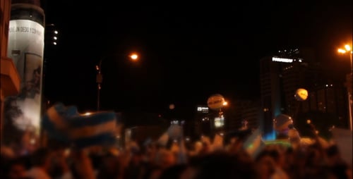 Large Crowd with Flags at Night in City