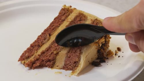 Slice of Chocolate Cake with Frosting Being Eaten
