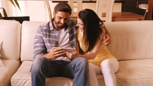 Couple Relaxing at Home Using Tablet