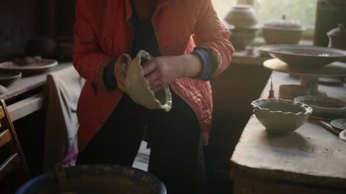 Elderly Woman Putting Out Pot in Workshop