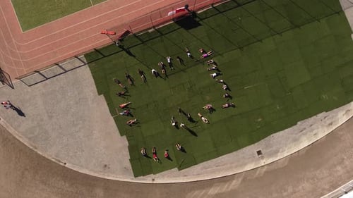 Enfants faisant des situps par piste de course, antenne rotative de haut en bas