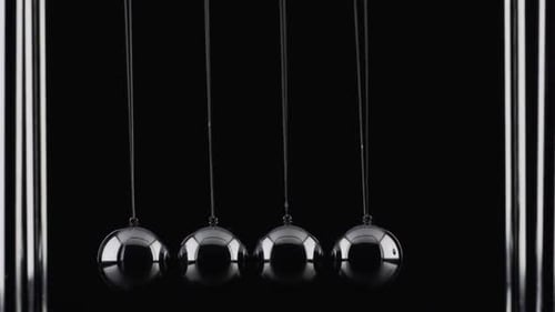 Die Kugeln einer Newtons Cradle kollidieren in Zeitlupe