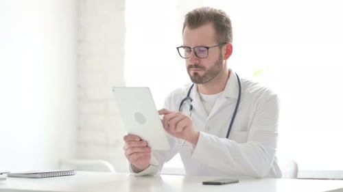Doctor Using Tablet While Sitting in Office