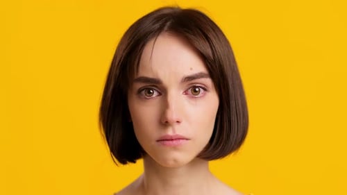 Young Adult Woman Crying with Tears on Yellow